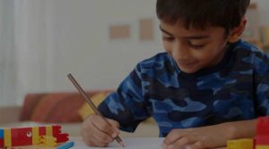 Boy enjoying drawing at home with overlay cropped