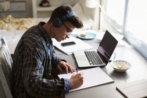 Student taking notes at home